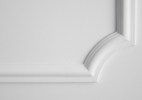 Decorative item made of white plaster on ceiling. Relief stucco interior